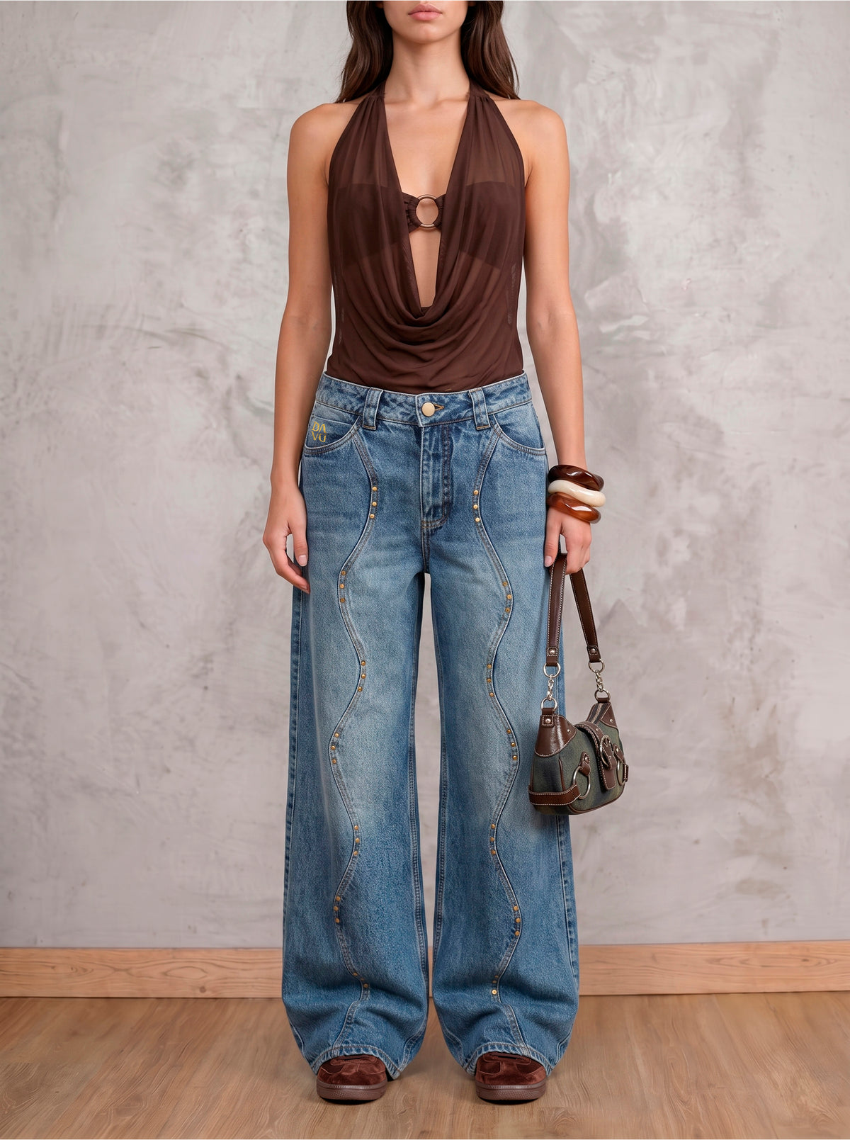 Jean azul medio wide leg Azurite de DAVD en vista frontal, silueta amplia con líneas curvas y aplicaciones metálicas en tono bronce.