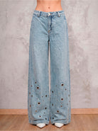 Detalle frontal del jean azul claro wide leg Arya de DAVD, aplicaciones tipo ojal sobre denim azul claro.