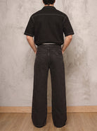 Jean negro wide leg Obsidian de DAVD en vista posterior masculina, silueta unisex amplia y bolsillos traseros.