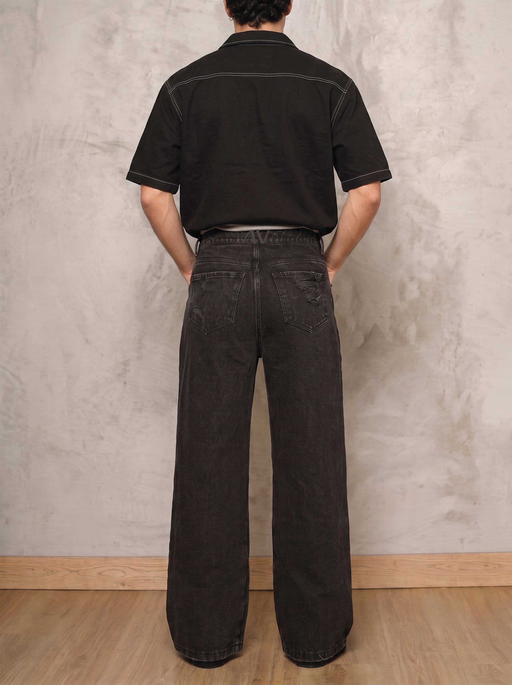 Jean negro wide leg Obsidian de DAVD en vista posterior masculina, silueta unisex amplia y bolsillos traseros.